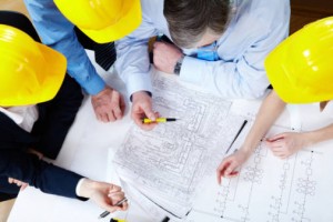Above view of four architects sitting at the table and discussing design project